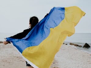 walking person holding blue and brown striped banner