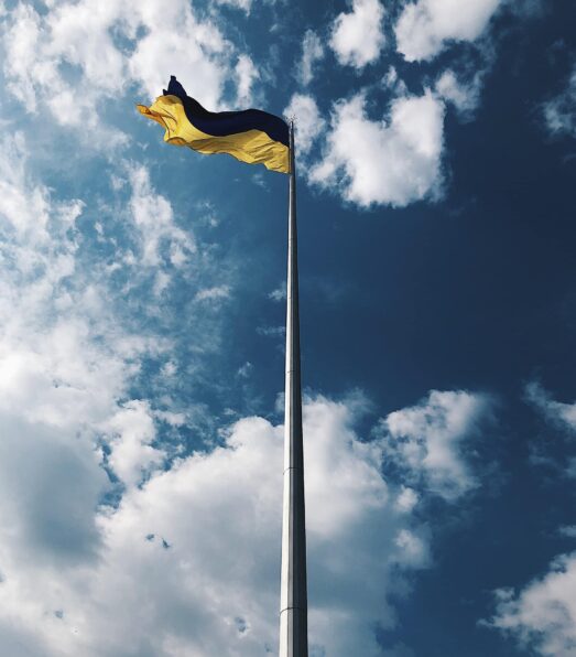 yellow flag under white clouds and blue sky during daytime